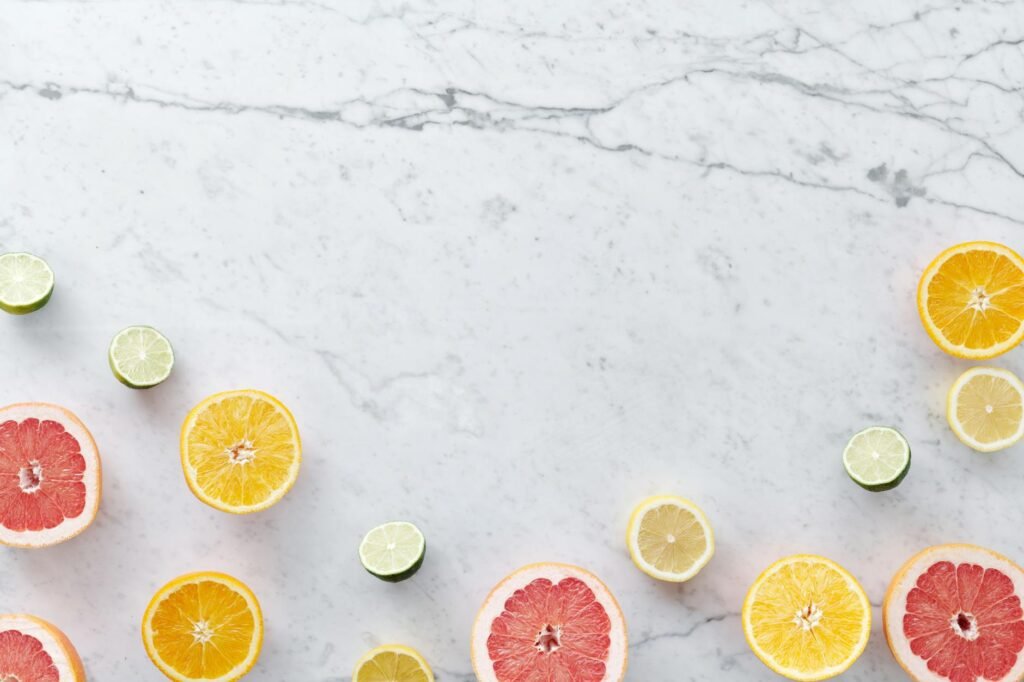 Calculator, grocery receipt, frozen fruit, and citrus on a table